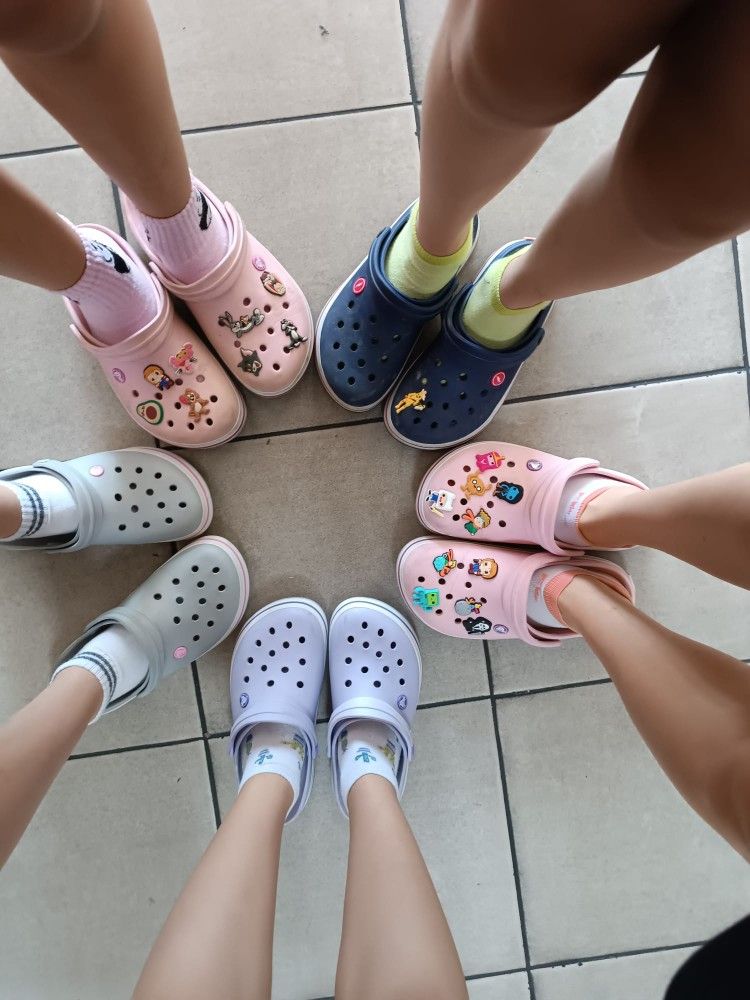 Friends in colorful clogs standing in a circle